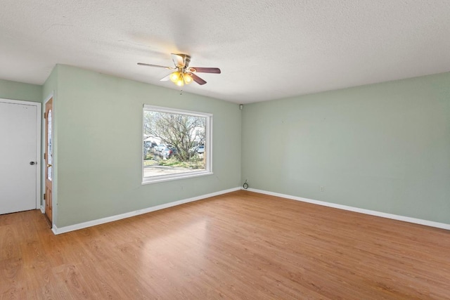 unfurnished room featuring light wood finished floors, a textured ceiling, baseboards, and a ceiling fan