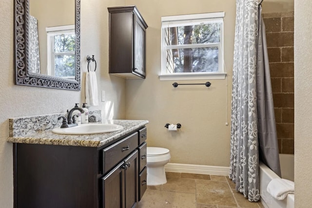 10033 Longhorn Skwy, Dripping Springs, TX 78620 - bathroom with toilet, vanity, baseboards, shower / tub combo with curtain, and stone tile flooring