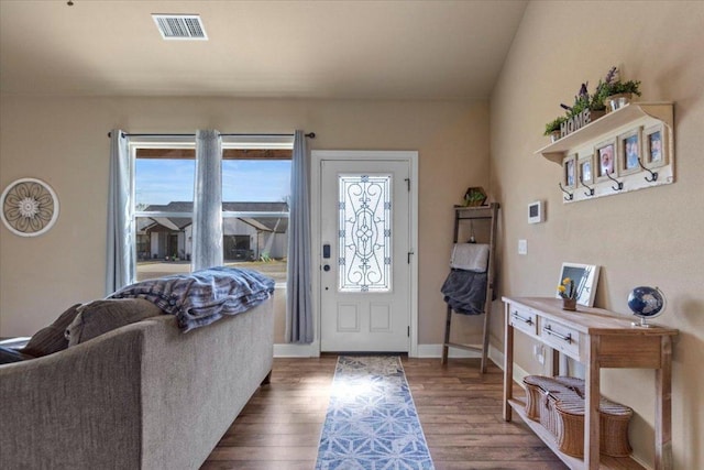 foyer entrance featuring visible vents, baseboards, and wood finished floors