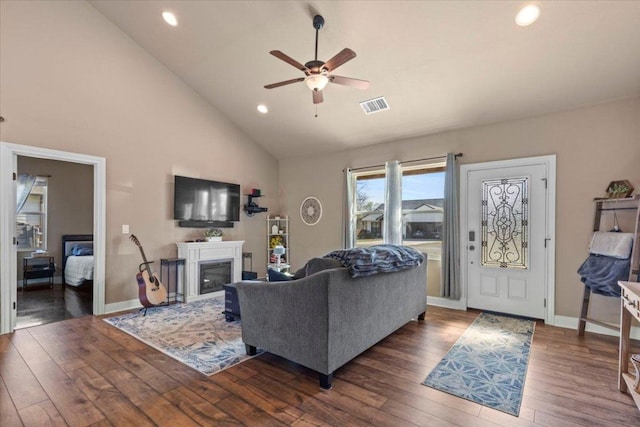 living area featuring visible vents, baseboards, ceiling fan, hardwood / wood-style floors, and a fireplace