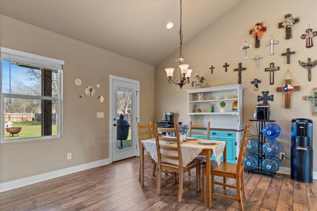 dining room with high vaulted ceiling, baseboards, an inviting chandelier, and wood finished floors