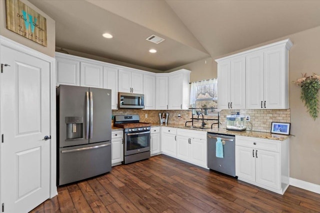 kitchen featuring a sink, lofted ceiling, backsplash, and appliances with stainless steel finishes