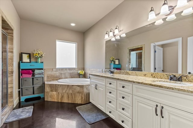 bathroom featuring a sink, a stall shower, double vanity, and a bath