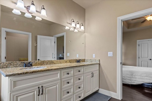 full bathroom featuring double vanity, a ceiling fan, baseboards, and a sink