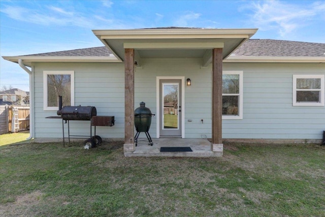 back of house with a patio area, a lawn, fence, and a shingled roof