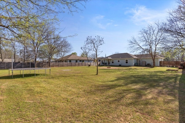 view of yard with a trampoline and a fenced backyard