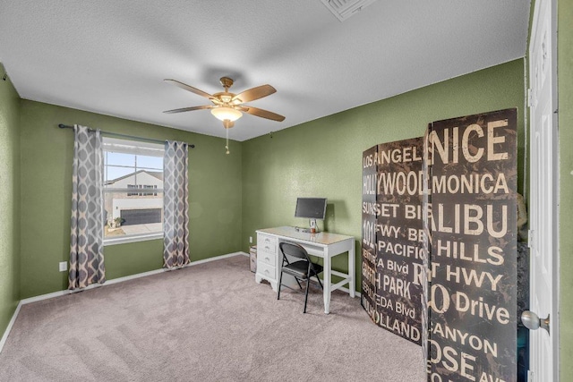 office area featuring a ceiling fan, visible vents, baseboards, a textured ceiling, and carpet flooring