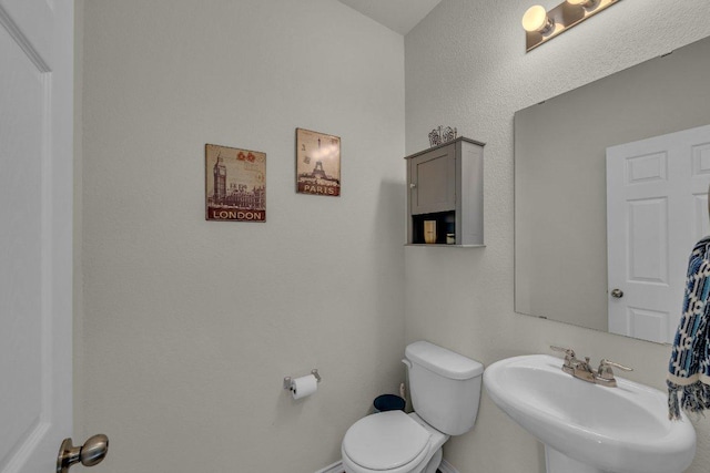 half bath with a sink and toilet