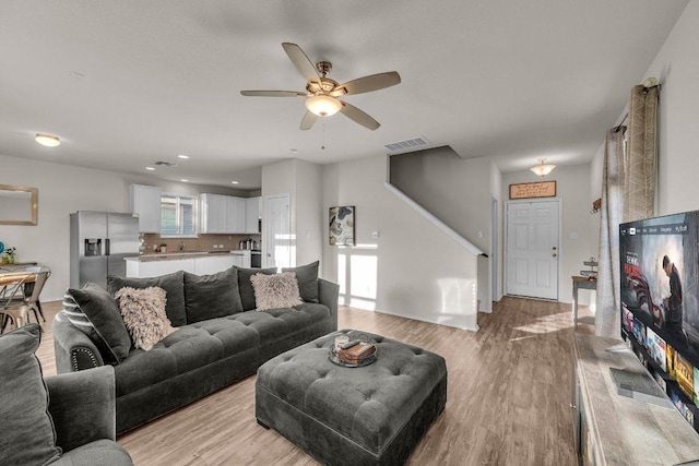 living area featuring visible vents, light wood-style flooring, and a ceiling fan