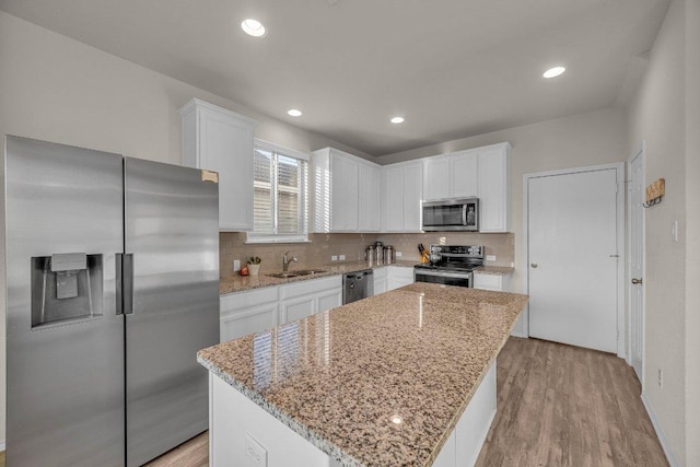 kitchen featuring a sink, white cabinets, tasteful backsplash, and stainless steel appliances