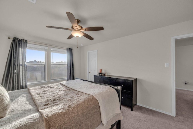 bedroom with ceiling fan, baseboards, and light carpet