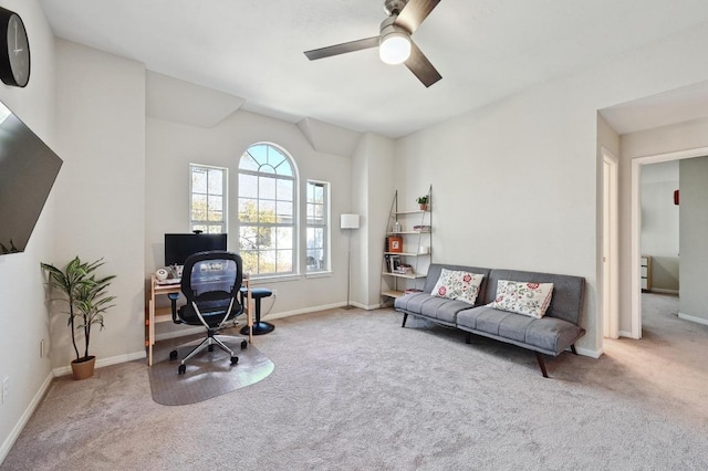 carpeted office with baseboards and a ceiling fan