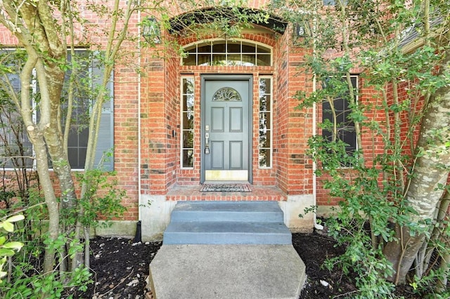doorway to property with brick siding