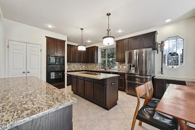kitchen with black appliances, a sink, backsplash, a center island, and dark brown cabinets