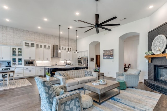 22306 Cape Travis Bnd, Lago Vista, TX 78645 - living area featuring wood finished floors, a ceiling fan, arched walkways, and visible vents