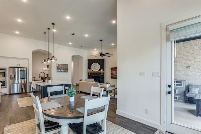 22306 Cape Travis Bnd, Lago Vista, TX 78645 - dining space with arched walkways, recessed lighting, dark wood-type flooring, and a ceiling fan