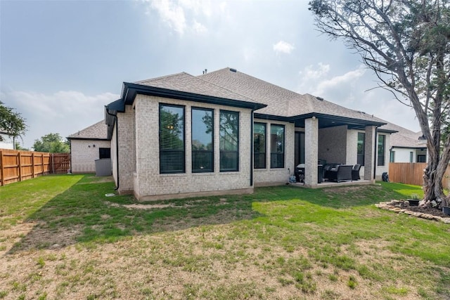 22306 Cape Travis Bnd, Lago Vista, TX 78645 - back of property with a yard, brick siding, a fenced backyard, and roof with shingles