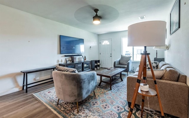 living area featuring visible vents, ceiling fan, and wood finished floors