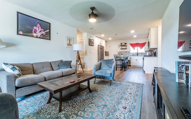 living area with recessed lighting, ceiling fan, and wood finished floors