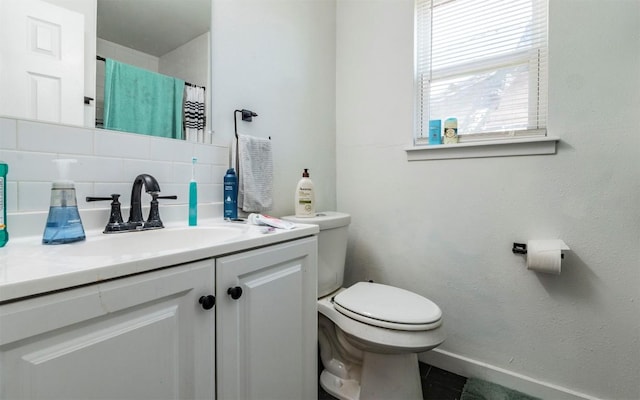 bathroom with vanity, a shower with curtain, baseboards, toilet, and tasteful backsplash