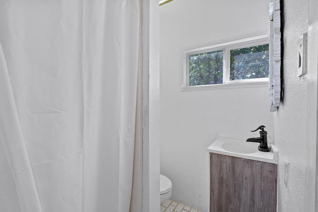 bathroom with curtained shower, toilet, and vanity