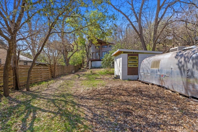 view of yard featuring an outdoor structure and fence