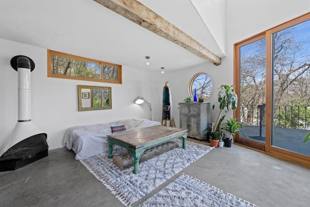 bedroom featuring beam ceiling, finished concrete flooring, a wood stove, and access to exterior