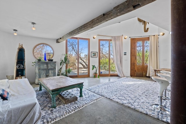 living area featuring lofted ceiling with beams and concrete flooring