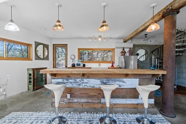 bar featuring beamed ceiling, pendant lighting, a wall unit AC, freestanding refrigerator, and concrete floors