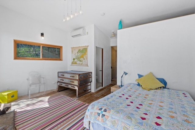 bedroom featuring a wall mounted air conditioner and wood finished floors