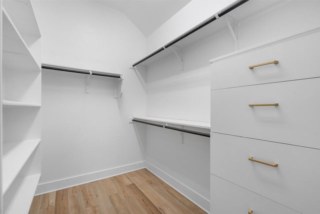 spacious closet featuring lofted ceiling and light wood finished floors