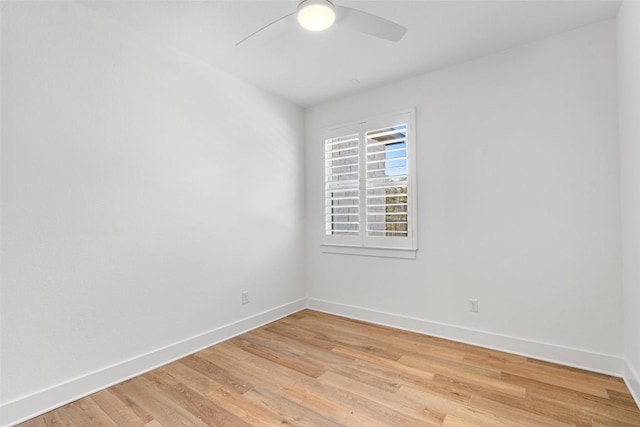 spare room with light wood-type flooring, baseboards, and a ceiling fan