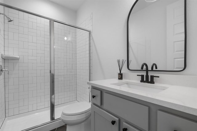 bathroom featuring vanity, a shower stall, and toilet