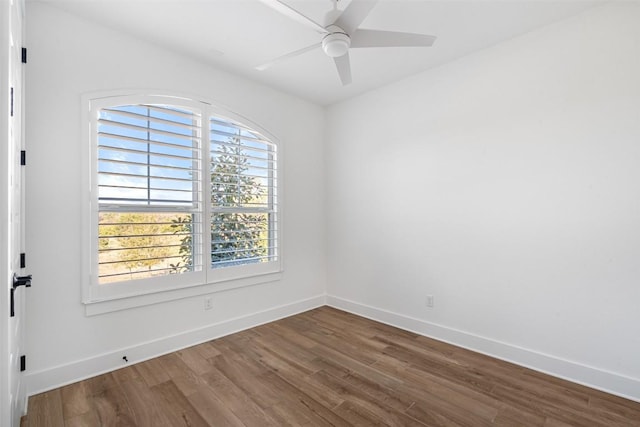 empty room featuring a ceiling fan, baseboards, and wood finished floors