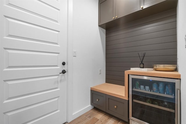 mudroom featuring wood finish floors, baseboards, and wine cooler