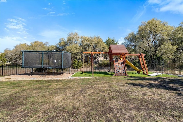 view of jungle gym with a trampoline, fence, and a lawn