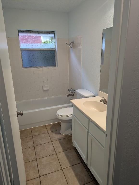 bathroom featuring tile patterned floors, toilet, vanity, and washtub / shower combination