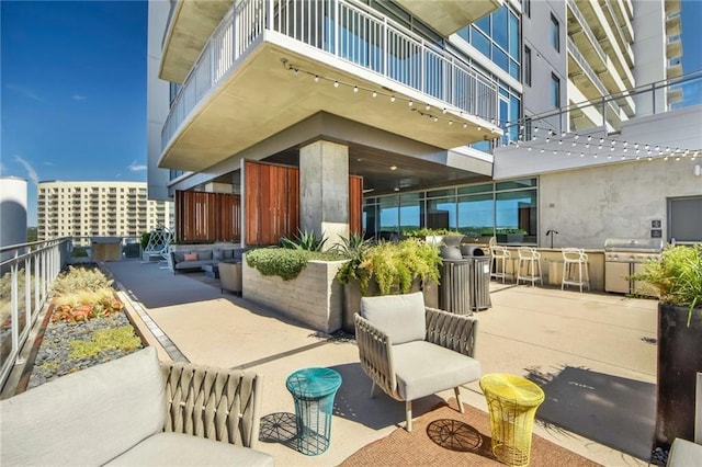 view of patio / terrace with outdoor dry bar, area for grilling, and a balcony