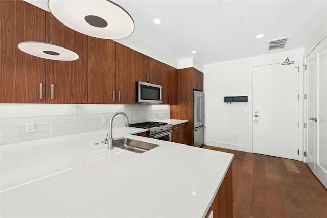 kitchen with a sink, visible vents, high quality appliances, and light countertops