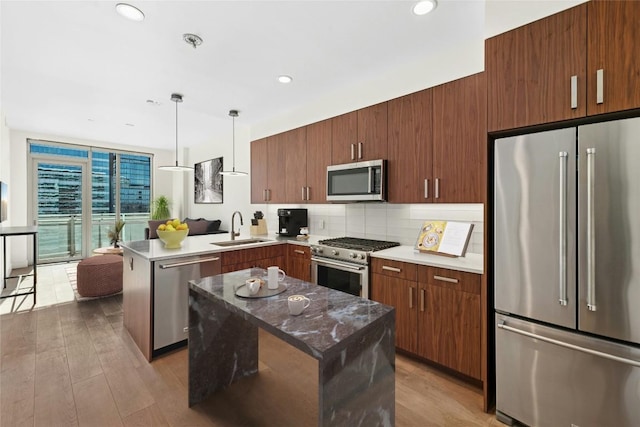 222 W Ave Unit 2109, Austin, TX 78701 - kitchen with appliances with stainless steel finishes, a sink, a peninsula, decorative backsplash, and hanging light fixtures
