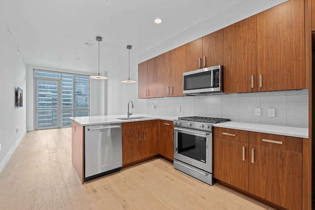 222 W Ave Unit 2109, Austin, TX 78701 - kitchen with appliances with stainless steel finishes, a peninsula, brown cabinets, backsplash, and expansive windows