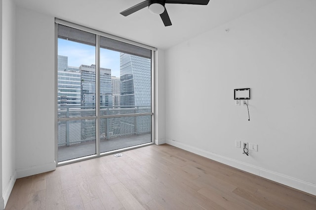 222 W Ave Unit 2109, Austin, TX 78701 - unfurnished room with floor to ceiling windows, wood finished floors, baseboards, a ceiling fan, and a view of city