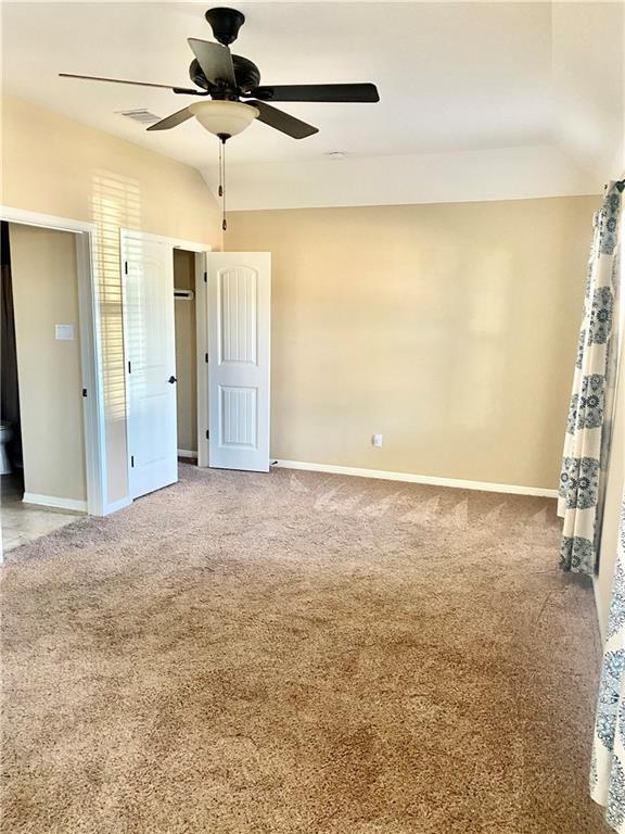 unfurnished bedroom featuring visible vents, baseboards, carpet, and a ceiling fan