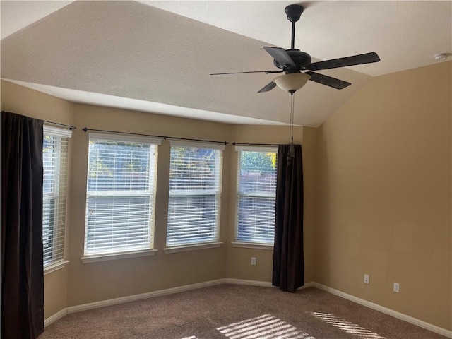 spare room featuring baseboards, carpet, a ceiling fan, and vaulted ceiling