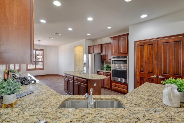 214 Apache Mountain Ln, Georgetown, TX 78633 - kitchen with light stone countertops, a sink, baseboards, stainless steel appliances, and recessed lighting