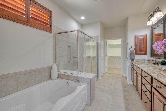 214 Apache Mountain Ln, Georgetown, TX 78633 - bathroom featuring vanity, a walk in closet, a bath, tile patterned floors, and a stall shower