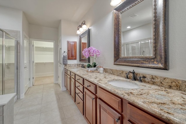 214 Apache Mountain Ln, Georgetown, TX 78633 - bathroom with visible vents, double vanity, a spacious closet, a sink, and a stall shower