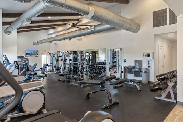 workout area featuring visible vents, a high ceiling, and a ceiling fan