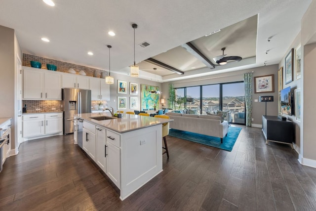 kitchen featuring dark wood finished floors, open floor plan, appliances with stainless steel finishes, and a sink