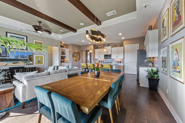 dining space featuring visible vents, beam ceiling, a ceiling fan, baseboards, and dark wood-style flooring